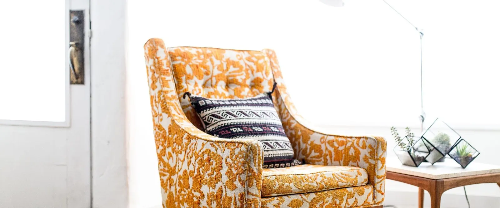 A patterned armchair in a bright room